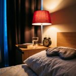 Contoured sleep mask on a pillow in a dark bedroom with blackout curtains and red-spectrum light